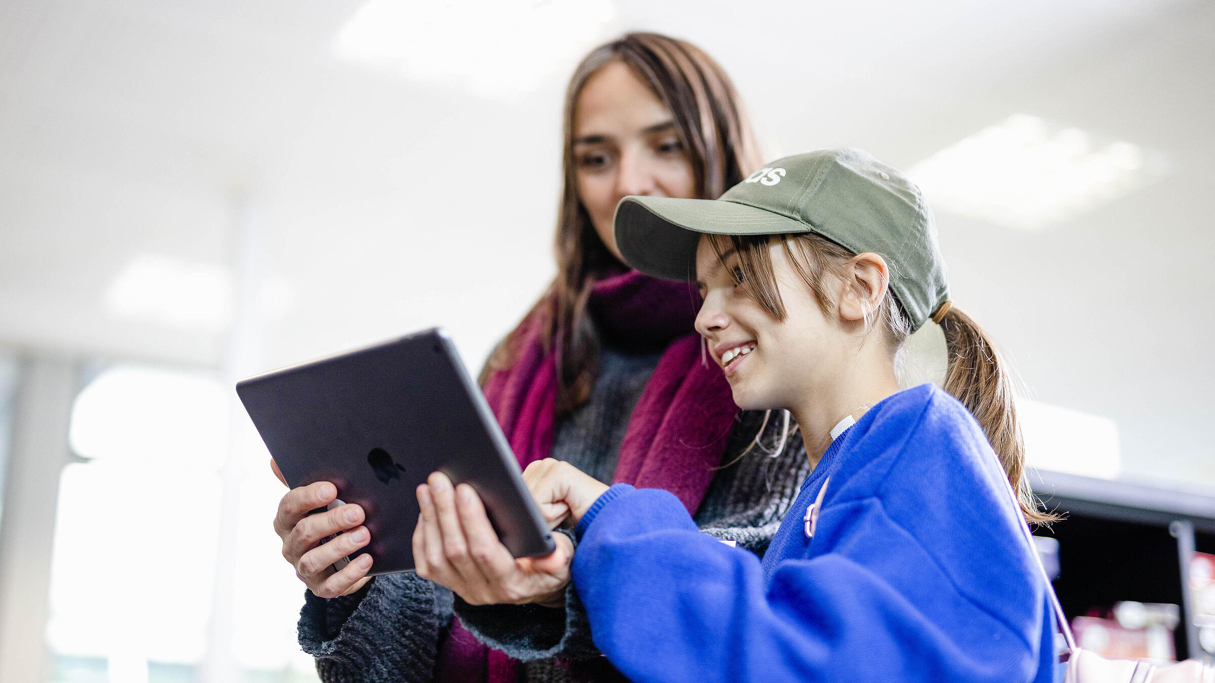 Mutter und Tochter schauen gemeinsam auf ein iPad