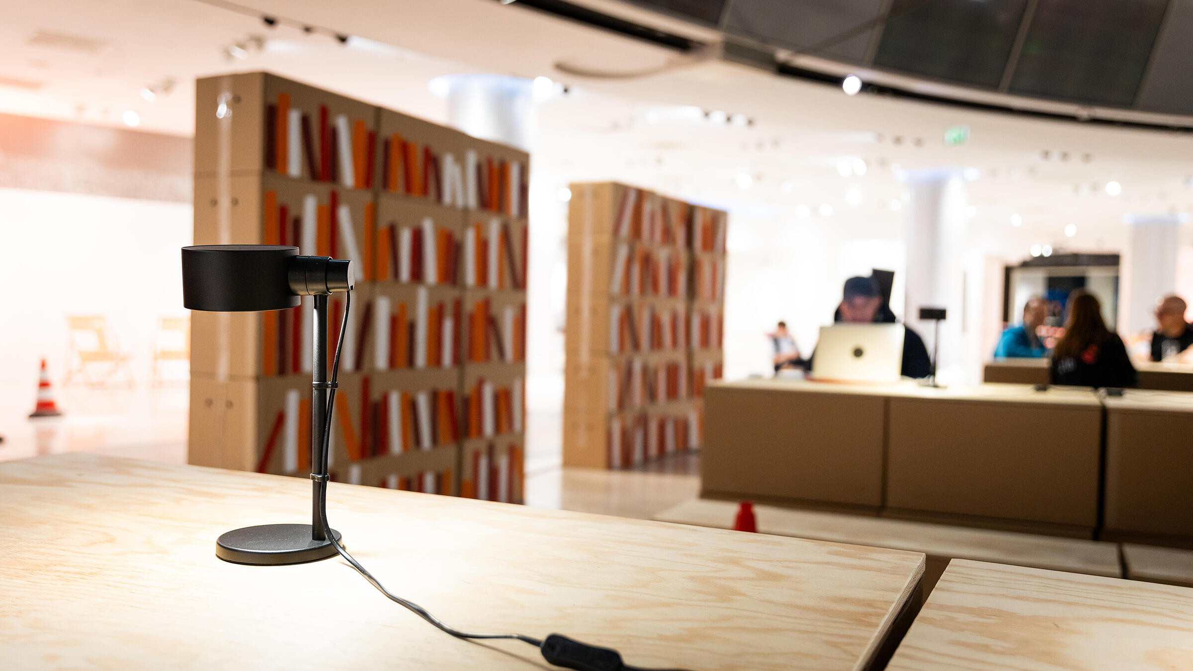 PopUp Biblothek gebaut aus Pappkartons im Q207 mit Arbeitstisch, Lampe und stilisiertem Regal