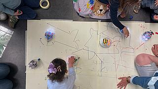 Foto von mit Robotern spielenden Kindern.
