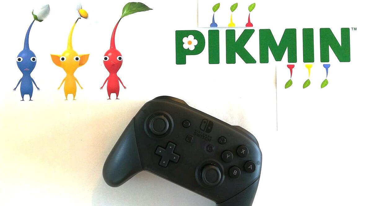 Foto eines Controllers und Darstellung von drei bunten Figuren und dem Schriftzug "Pikmin"