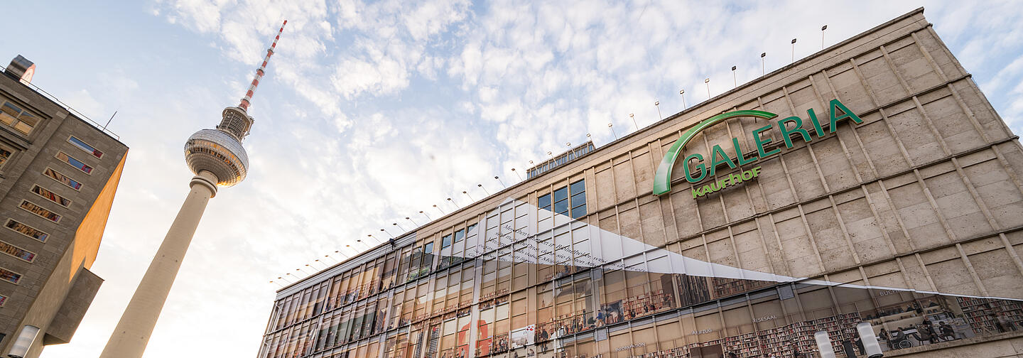 Foto von Alexanderplatz mit Gebäude, das als Bibliothek an der Fassade beklebt ist
