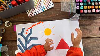 Kinderhände, die ein buntes Bild gestalten