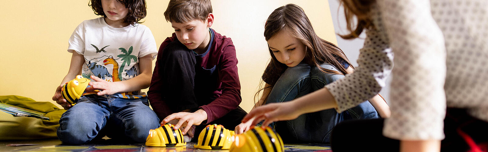 Mehrere Kinder spielen mit Beetlebots in der KiJuBi