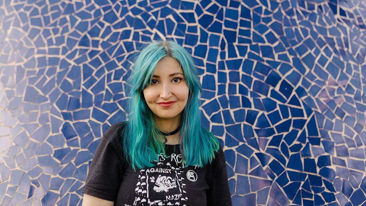 Porträt von Melina Borčak vor blauer Keramikwand