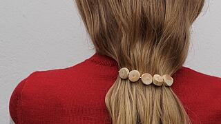 Ein Mädchen mit langen Haaren trägt einen Schmuck