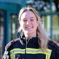 Portrait der angehenden Feuerwehrfrau Anna Haberland vor dem Eingang der AGB