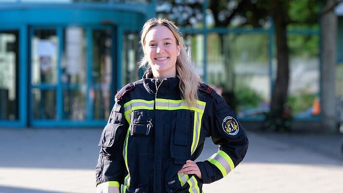 Portrait der angehenden Feuerwehrfrau Anna Haberland vor dem Eingang der AGB