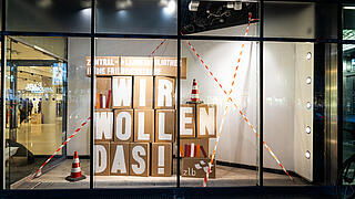 Schaufenster des Q207 mit Umzugskartons mit der Aufschrift wir wollen das