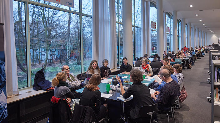 Gefüllter Tisch in der Lesehalle der AGB wo gemeinsam gelesen wird