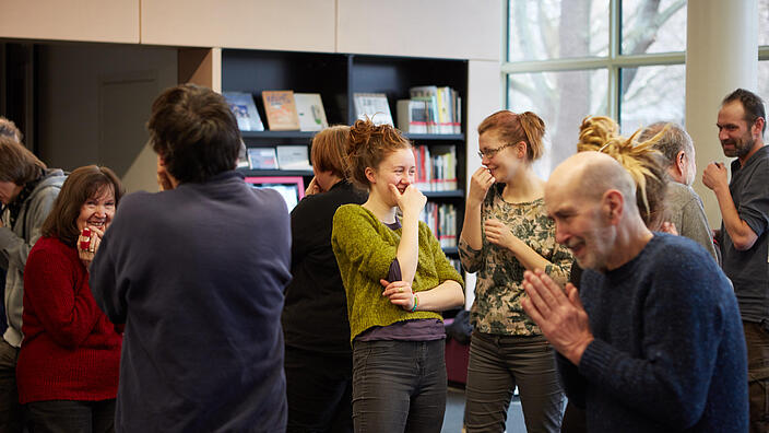 People doing laughter yoga in the salon of AGB