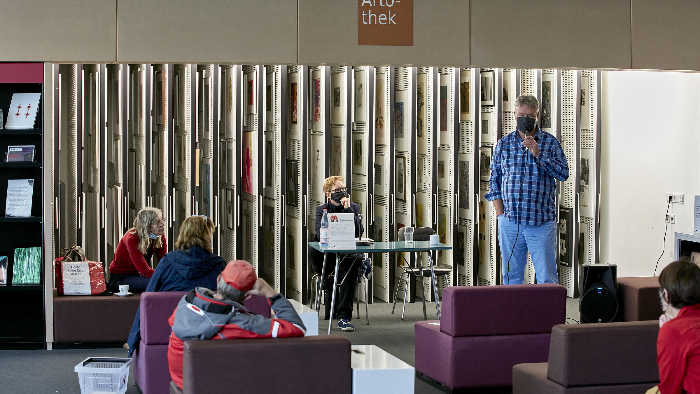 Discussion event in the salon of the AGB with audience and a speaker with microphone in hand