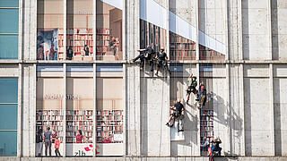 Höhenkletterer bekleben die Fassade von Galeria Kaufhof am Alexanderplatz