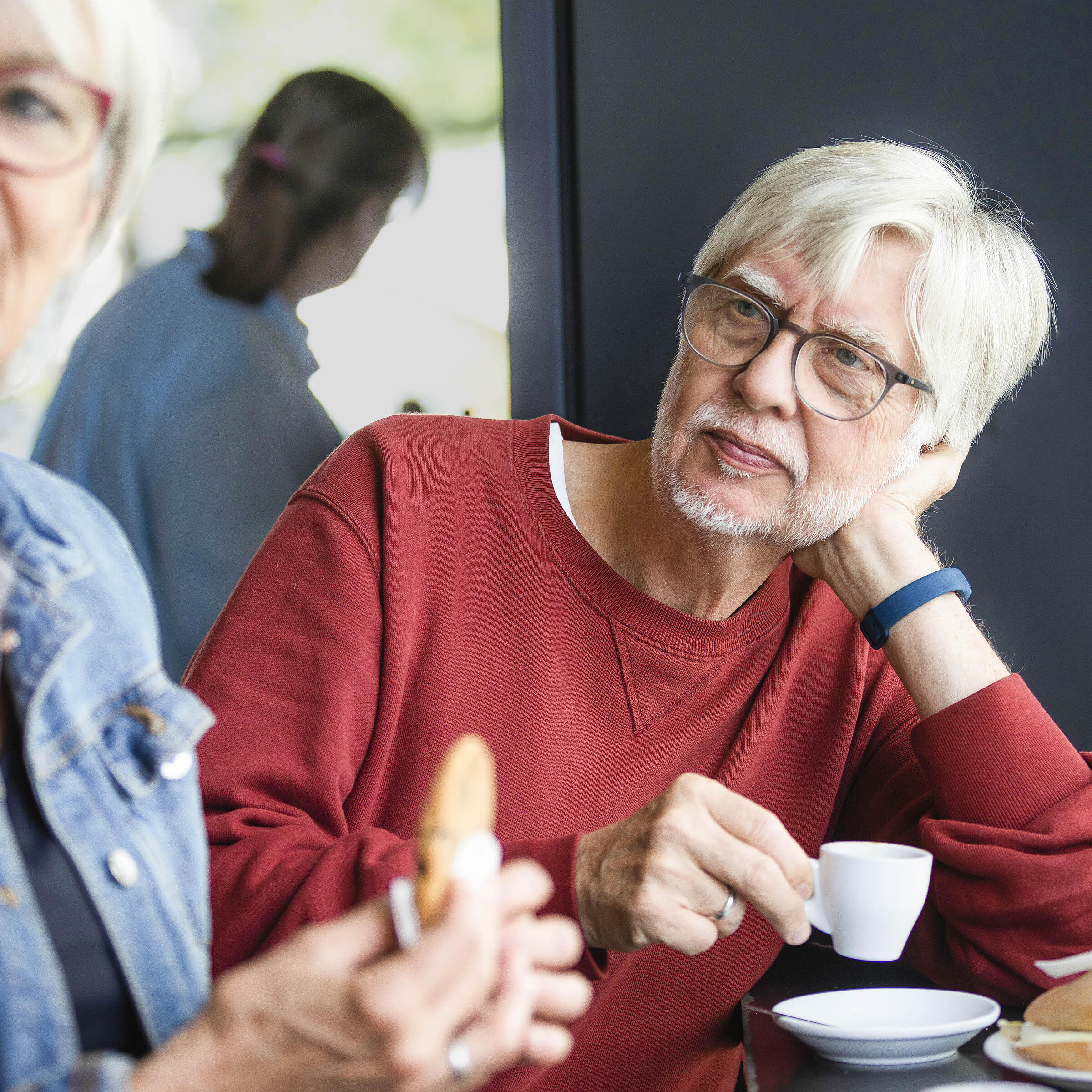 Elderly couple sitting in the AGB coffee shop drinking an espresso and eating a biscuit