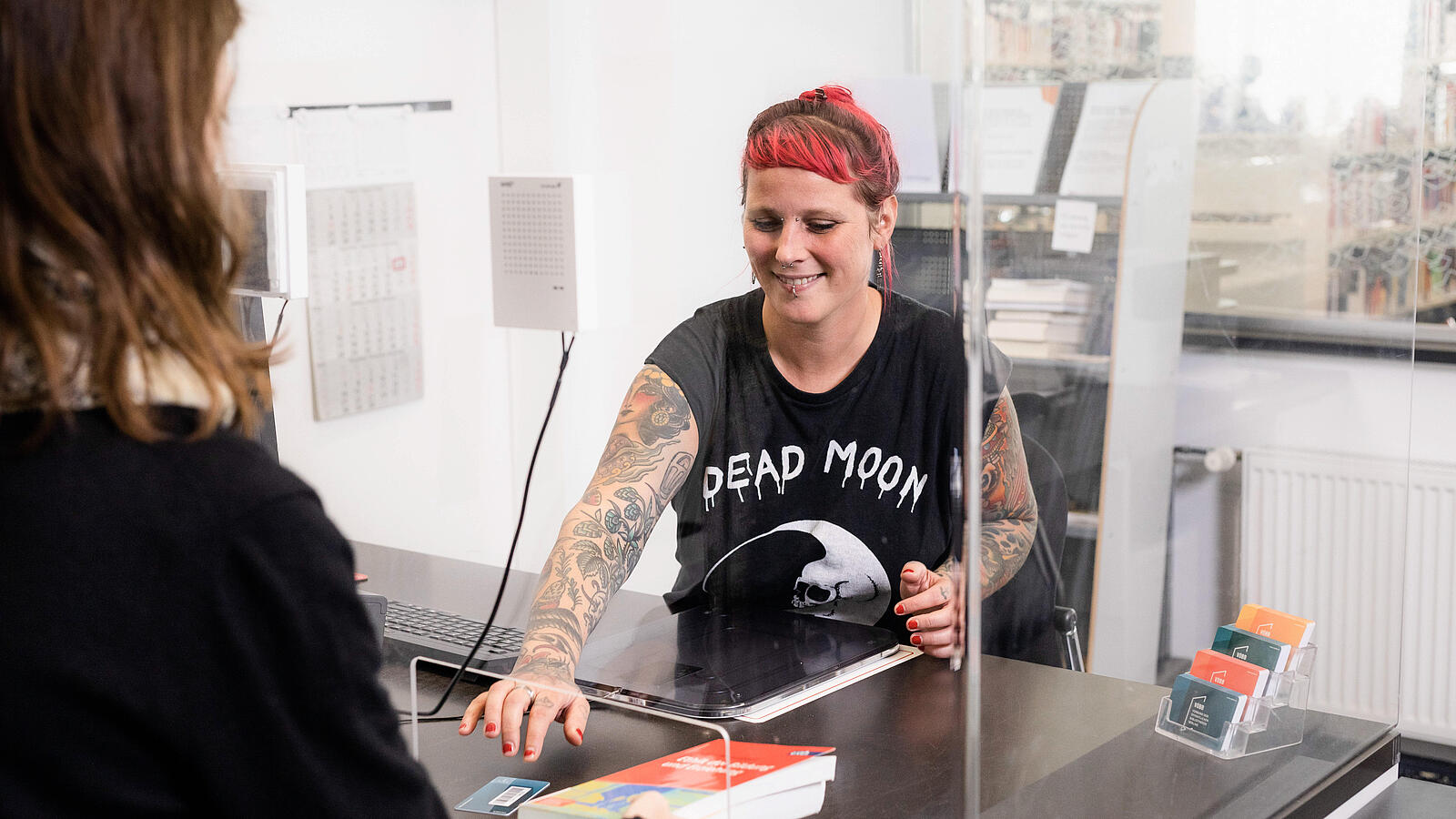 Photo of someone extending the customer's books at the service desk in the library