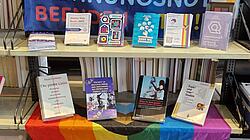 Foto der aktuellen Medienpräsentation mit Büchern und einer Pride-Fahne